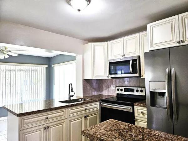 a kitchen with stainless steel appliances granite countertop a refrigerator sink and stove