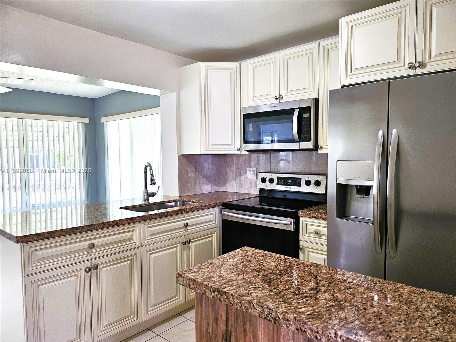 1040 Northwest 73rd Terrace Margate, FL 33063 - Photo 16 of 41 a kitchen with stainless steel appliances granite countertop a stove a sink dishwasher a refrigerator and cabinets with wooden floor
