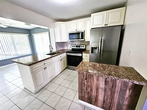 a kitchen with sink cabinets and refrigerator