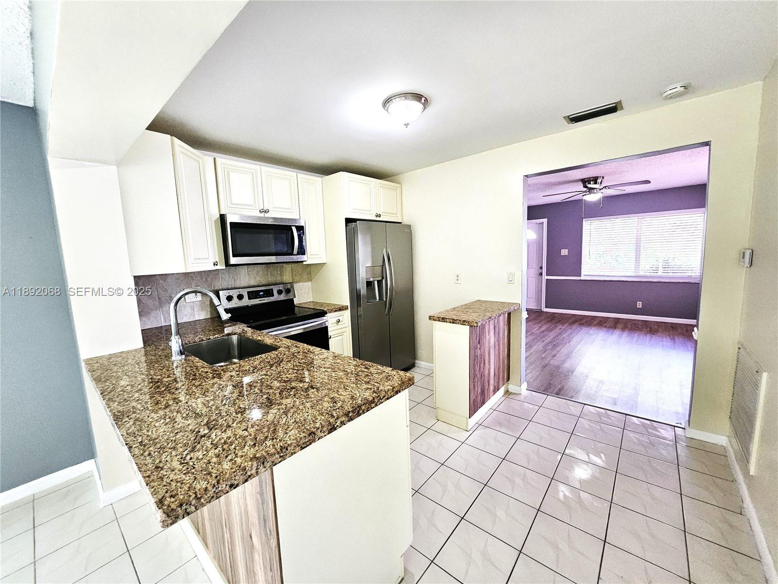 1040 Northwest 73rd Terrace Margate, FL 33063 - Photo 18 of 41 a kitchen with sink cabinets and refrigerator