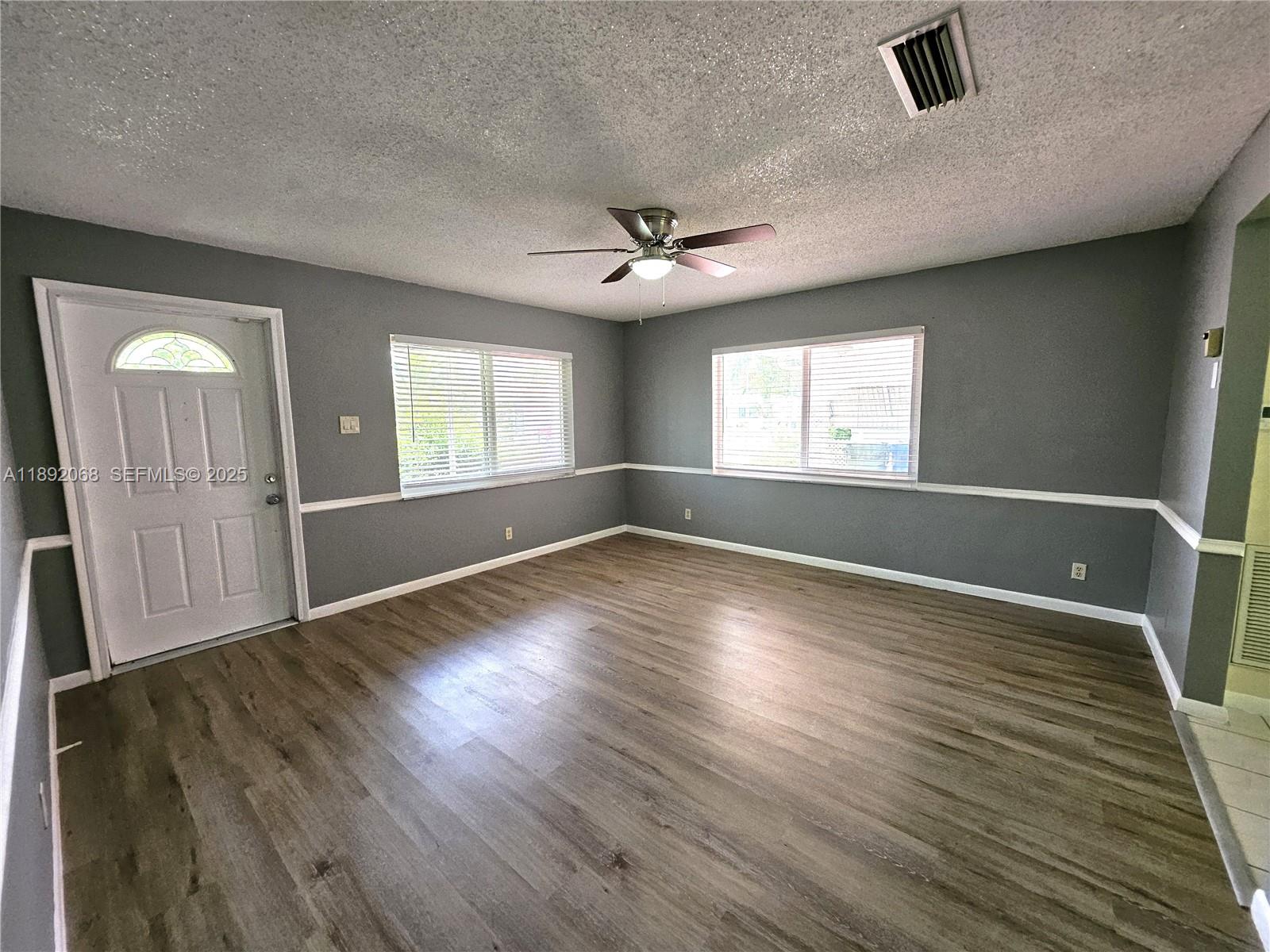 1040 Northwest 73rd Terrace Margate, FL 33063 - Photo 23 of 41 an empty room with wooden floor and windows
