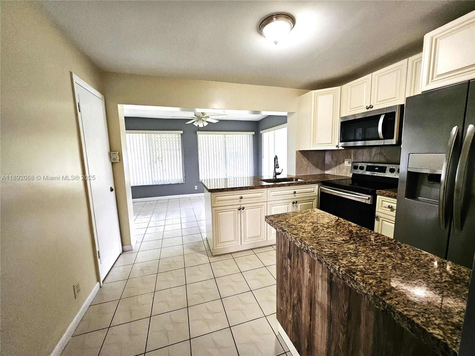 1040 Northwest 73rd Terrace Margate, FL 33063 - Photo 33 of 41 a kitchen with stainless steel appliances granite countertop a stove a sink and a refrigerator