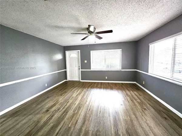 a bedroom with wooden floor and a window