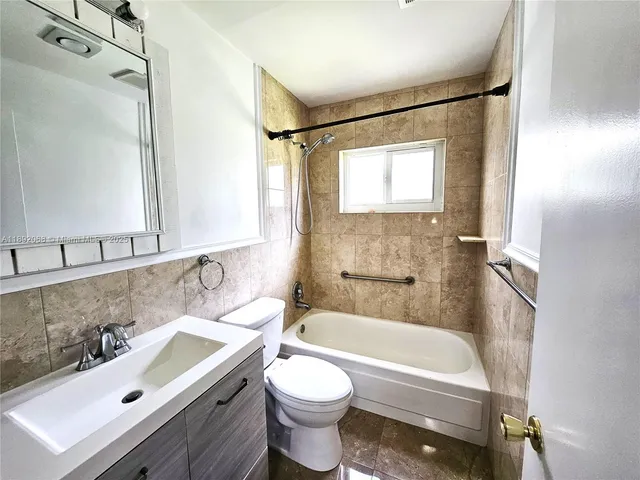 a bathroom with a sink mirror toilet and bathtub