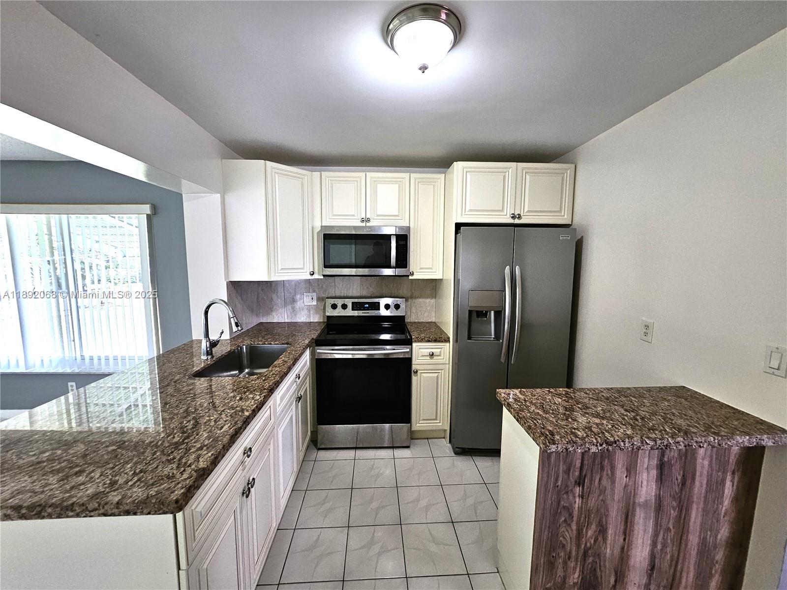 1040 Northwest 73rd Terrace Margate, FL 33063 - Photo 6 of 41 a kitchen with granite countertop a refrigerator stove and sink
