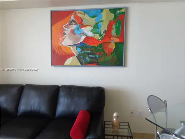 a living room with furniture and wall paintings