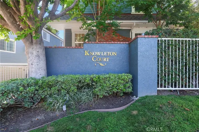 a sign that is sitting in front of a brick house