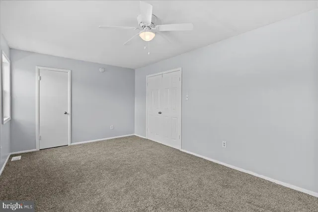 a view of an empty room with a ceiling fan