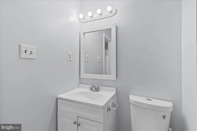 a bathroom with a sink a toilet and a mirror