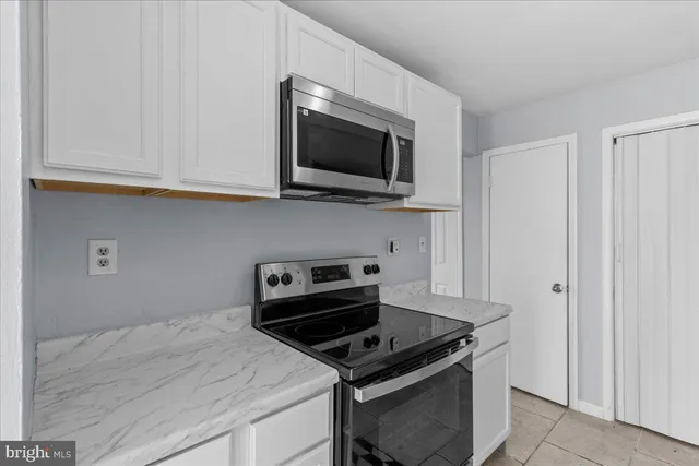 a kitchen with stainless steel appliances granite countertop a stove and a microwave