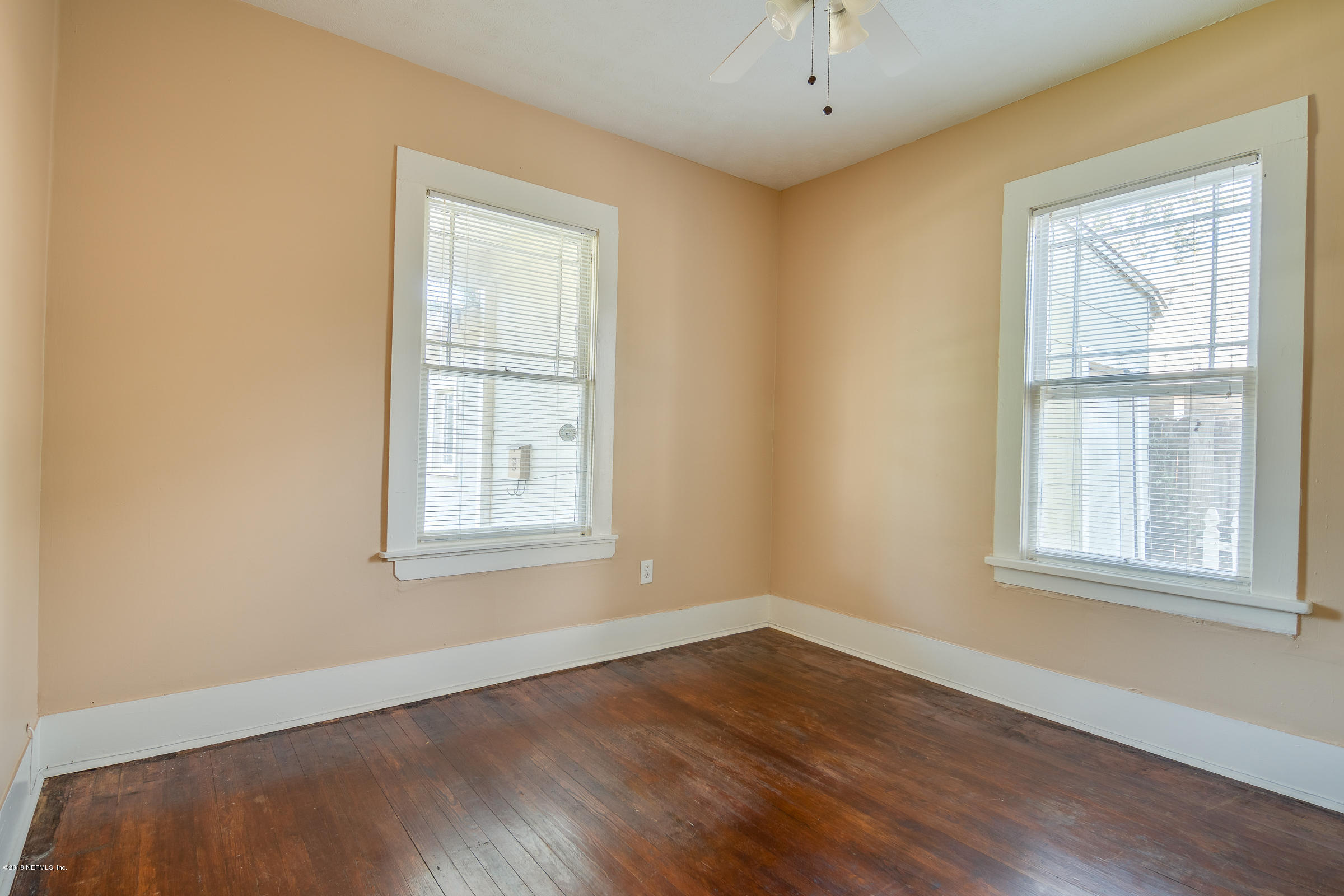 1509 Mayfair Road Jacksonville, FL 32207 - Photo 11 of 22 an empty room with wooden floor and windows