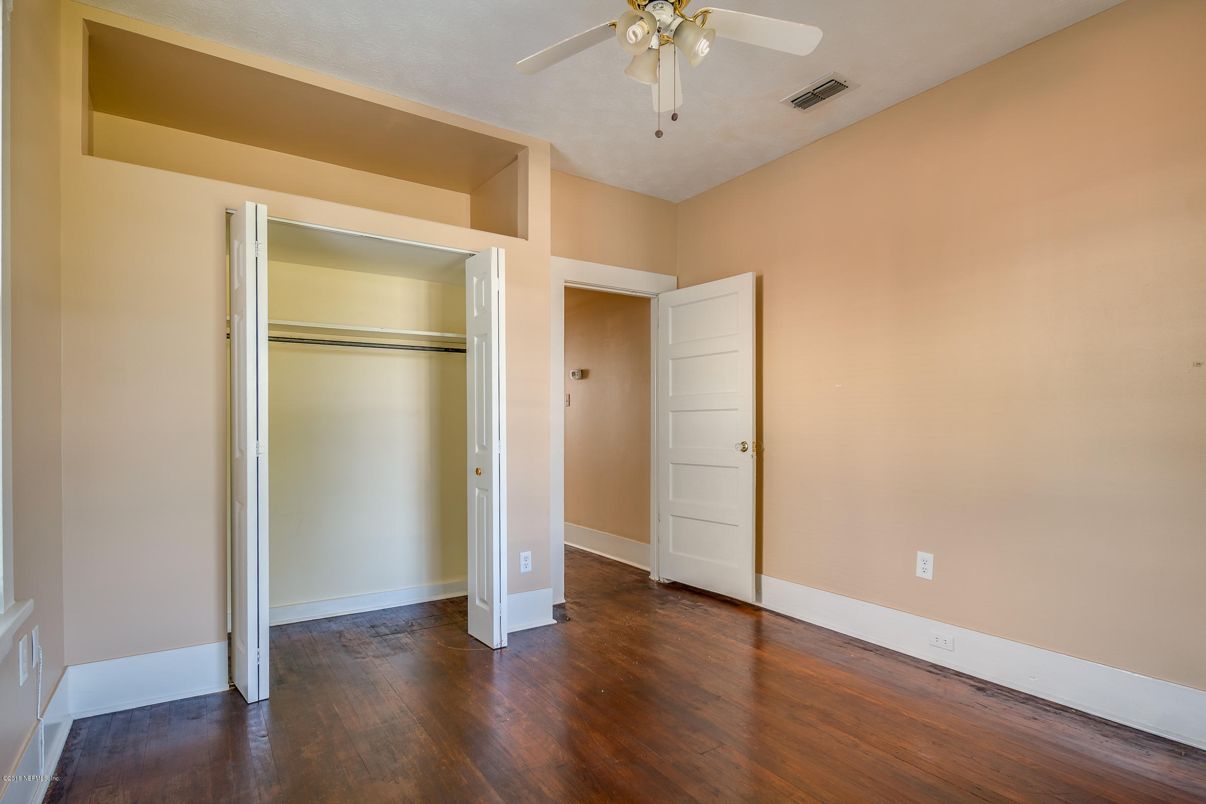 1509 Mayfair Road Jacksonville, FL 32207 - Photo 12 of 22 a view of an empty room with a window and wooden floor