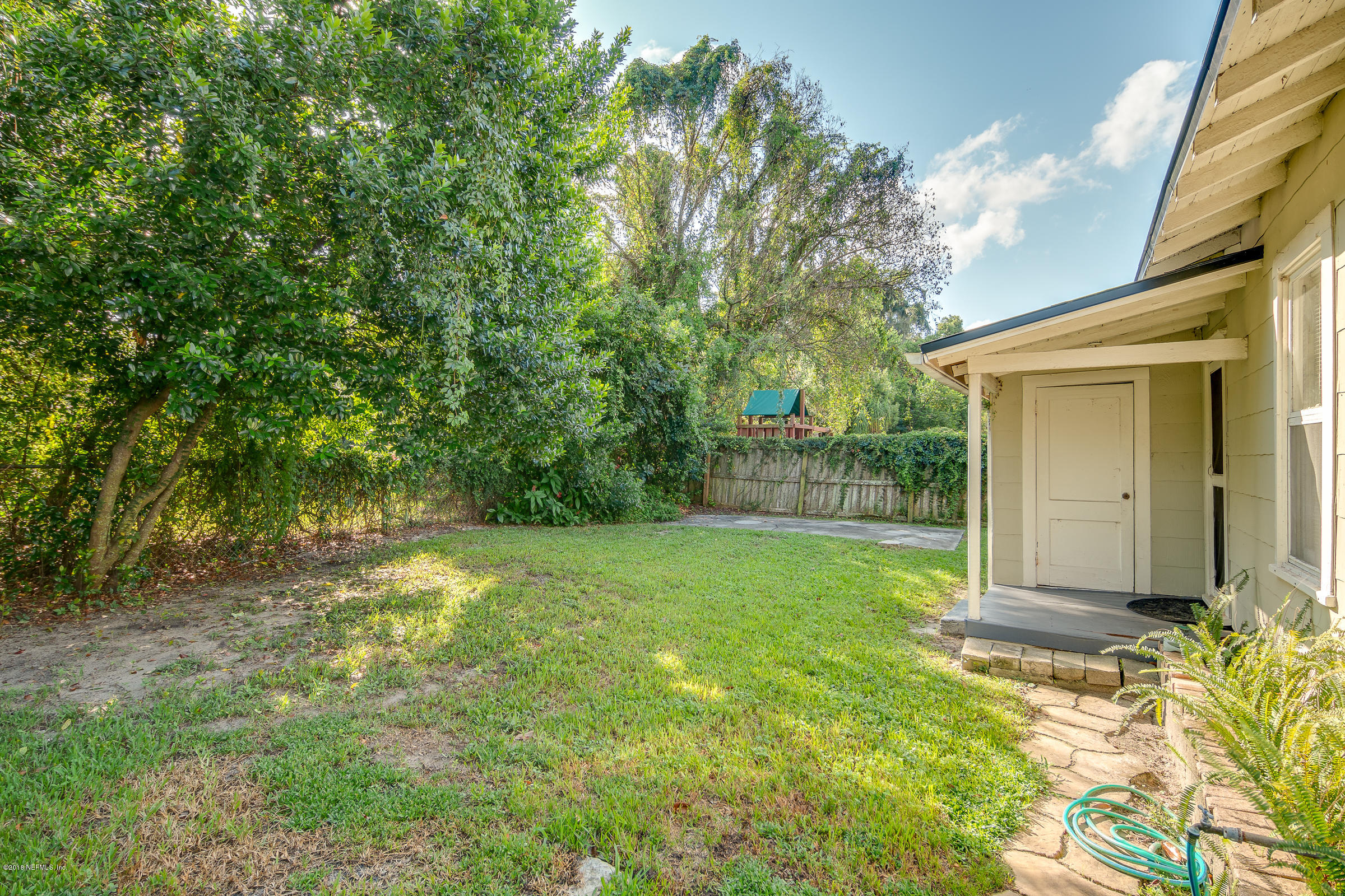 1509 Mayfair Road Jacksonville, FL 32207 - Photo 6 of 22 a backyard of a house with plants and large trees