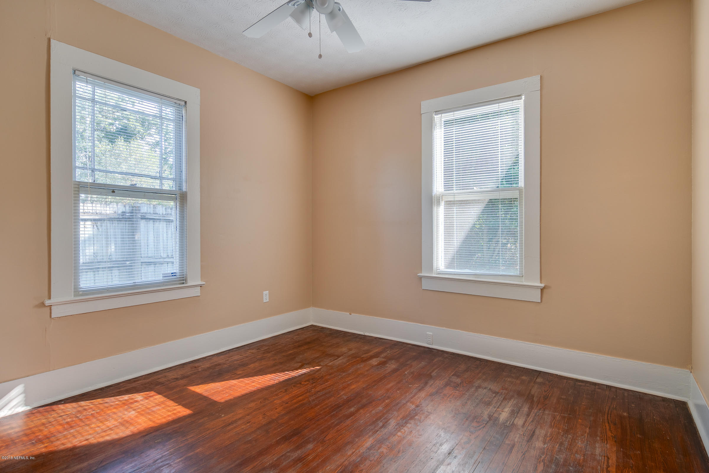 1509 Mayfair Road Jacksonville, FL 32207 - Photo 10 of 22 an empty room with wooden floor and windows