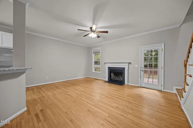 a view of empty room with a fireplace and wooden floor