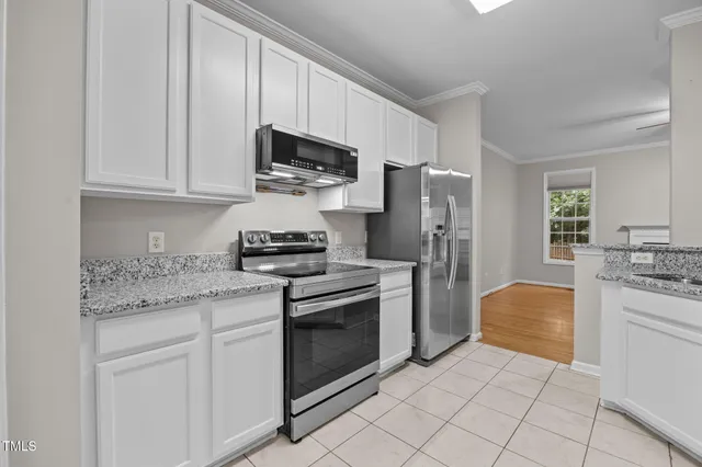 a kitchen with stainless steel appliances granite countertop a stove a refrigerator and a microwave