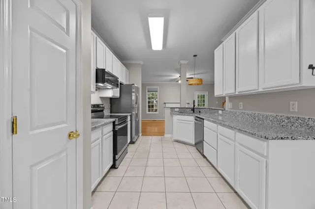 a kitchen with stainless steel appliances granite countertop a refrigerator and a stove top oven