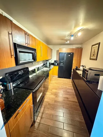 a kitchen with granite countertop stainless steel appliances and wooden cabinets