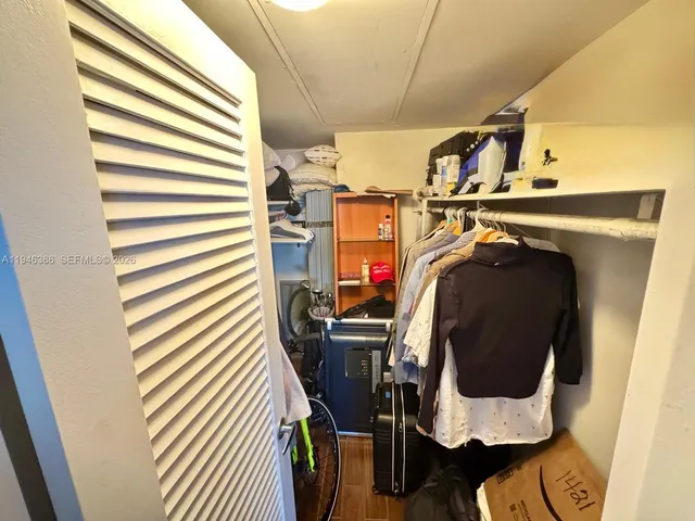 a view of walk in closet with clothes and shoes