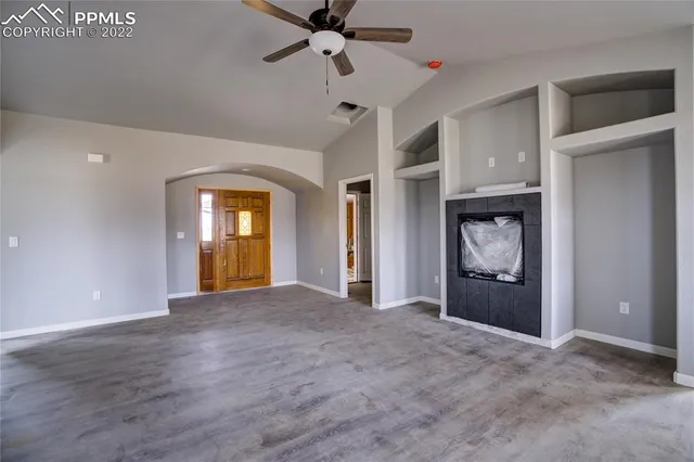 a view of empty room with a fireplace and fan