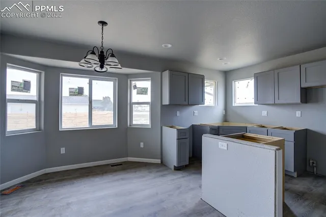 a kitchen with stainless steel appliances granite countertop a sink a stove and a wooden floors