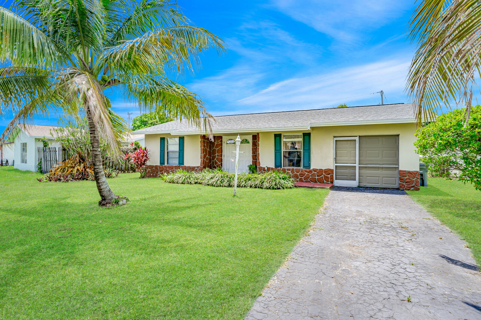 22243 Southwest 64th Way Boca Raton, FL 33428 - Photo 2 of 47 a front view of a house with a yard and palm tree