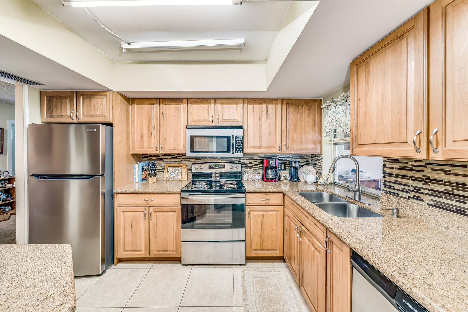 22243 Southwest 64th Way Boca Raton, FL 33428 - Photo 9 of 47 a kitchen with stainless steel appliances granite countertop a refrigerator sink and stove