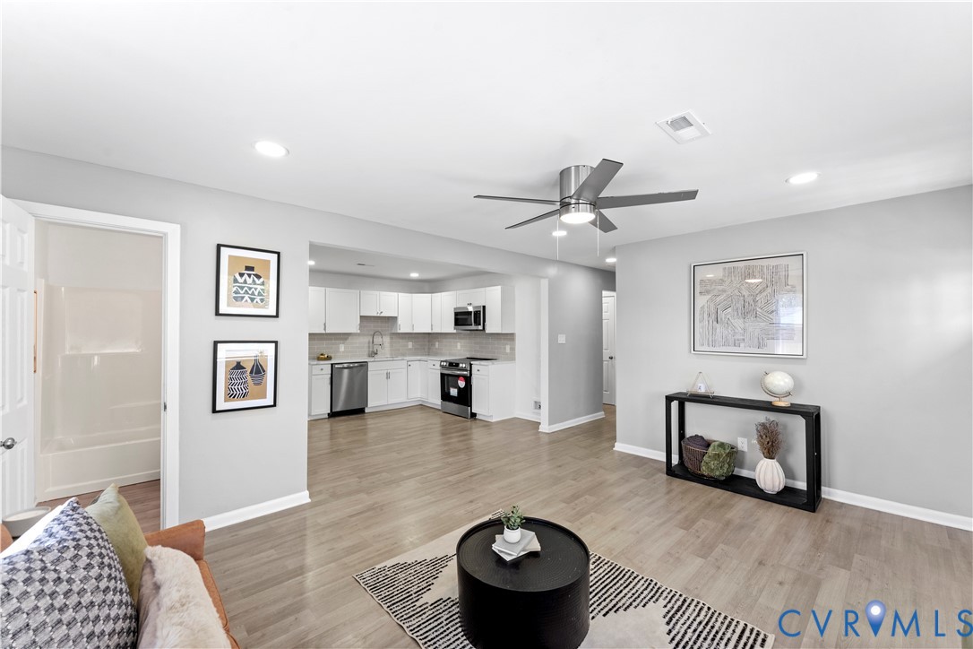 Living area with light wood-style floors, recessed