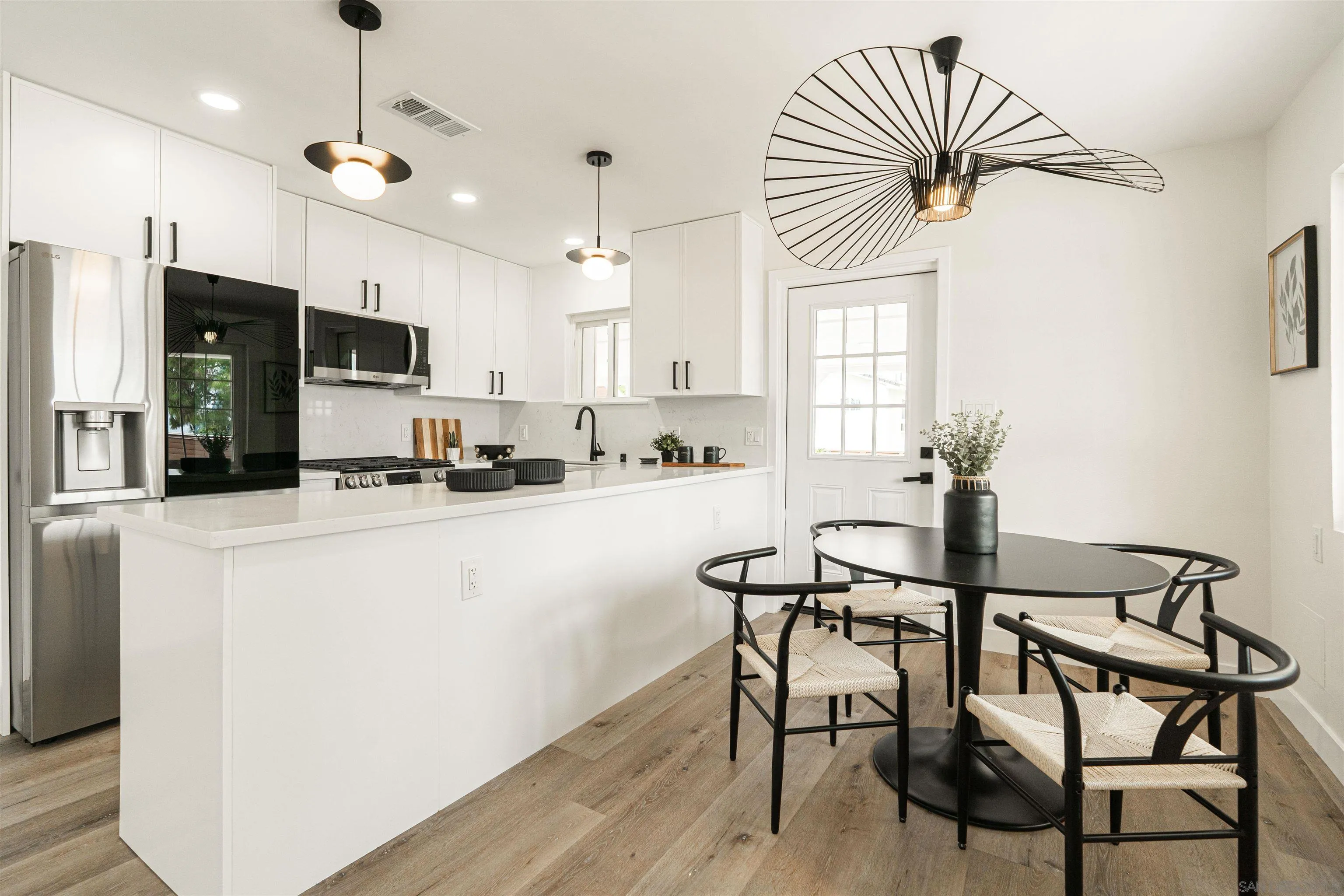 9376 Starcrest Drive Santee, CA 92071 - Photo 2 of 39 a kitchen with stainless steel appliances a dining table chairs refrigerator and sink