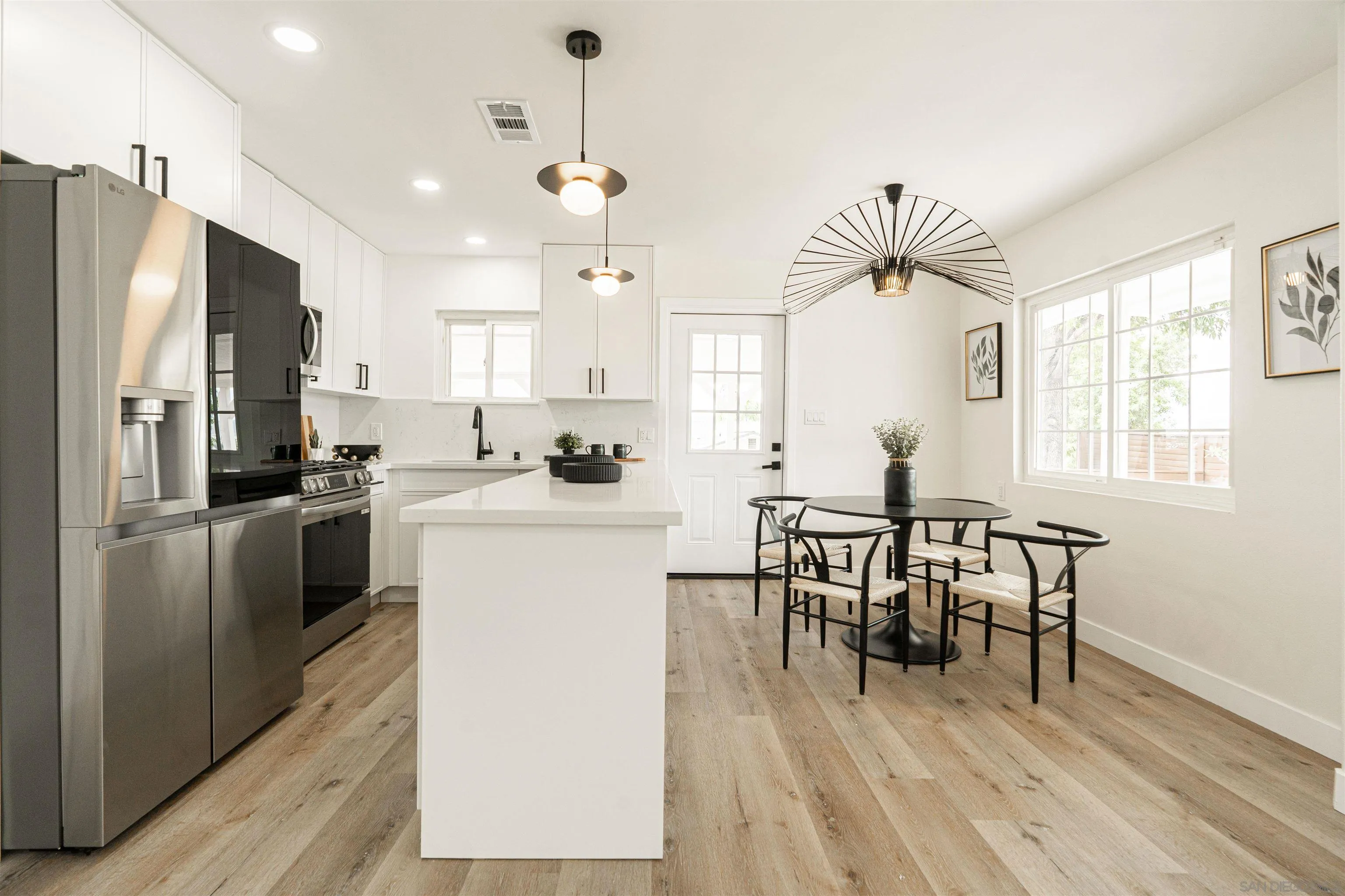 9376 Starcrest Drive Santee, CA 92071 - Photo 26 of 39 a kitchen with a table chairs refrigerator and microwave