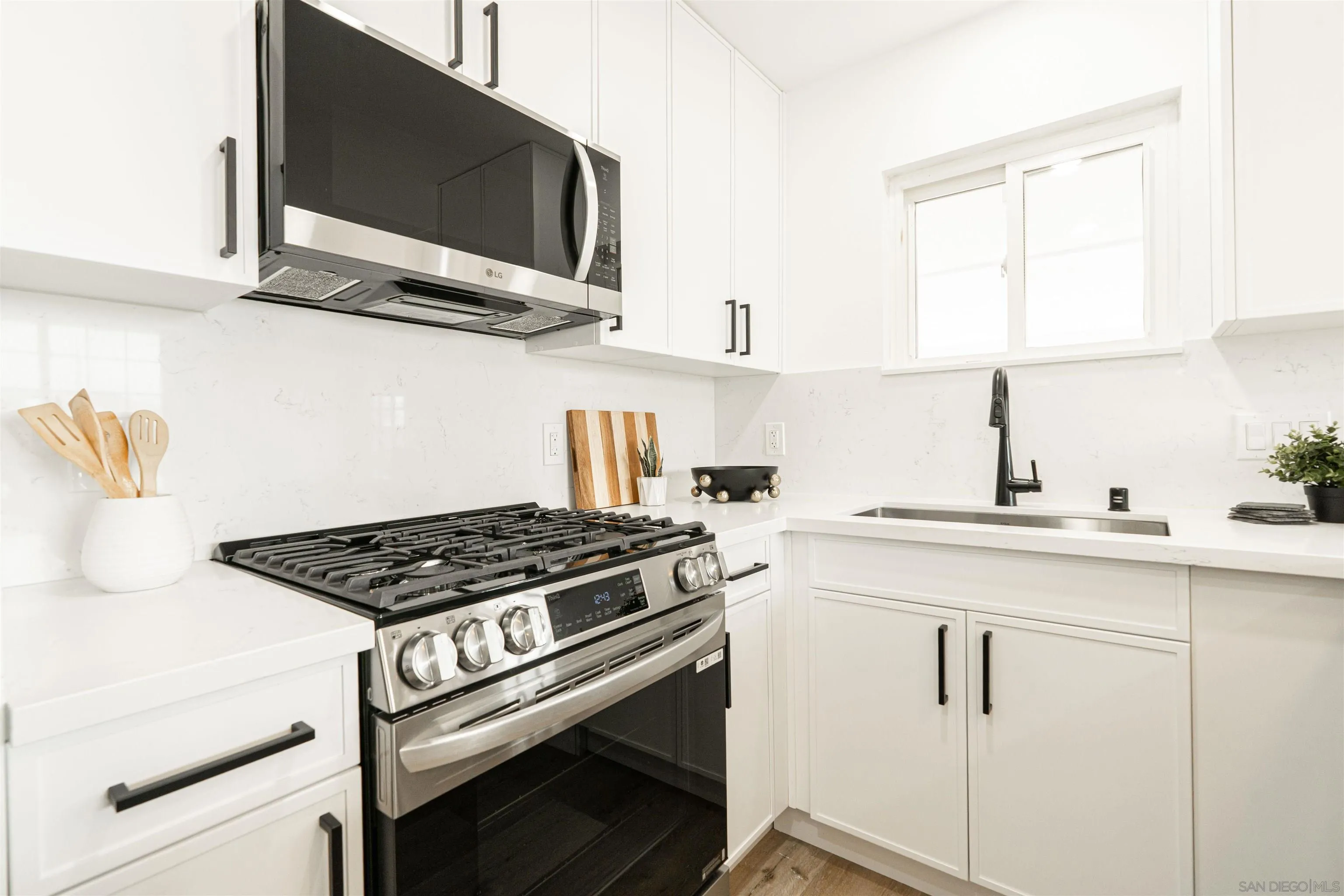 9376 Starcrest Drive Santee, CA 92071 - Photo 4 of 39 a kitchen with stainless steel appliances a stove a microwave a sink and cabinets