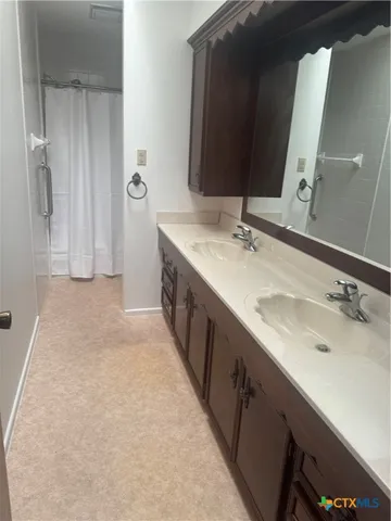 a view of an empty room with wooden floor and a fireplace