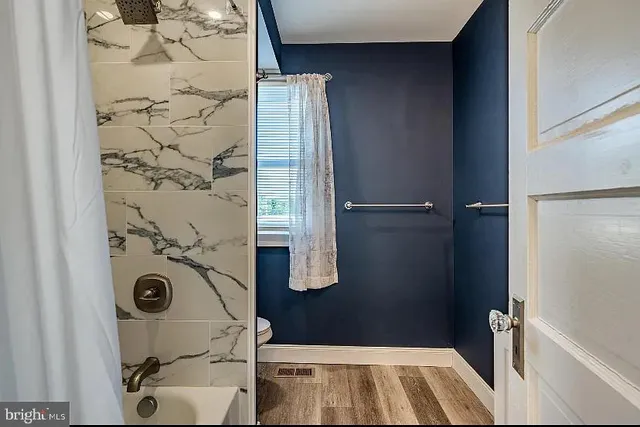 a bathroom with a granite countertop shower and a sink