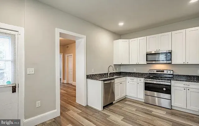 a kitchen with stainless steel appliances granite countertop a stove and a refrigerator
