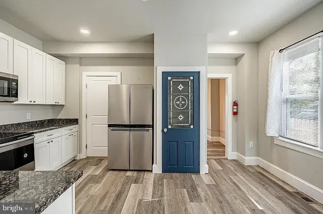 a kitchen with a refrigerator and a stove top oven