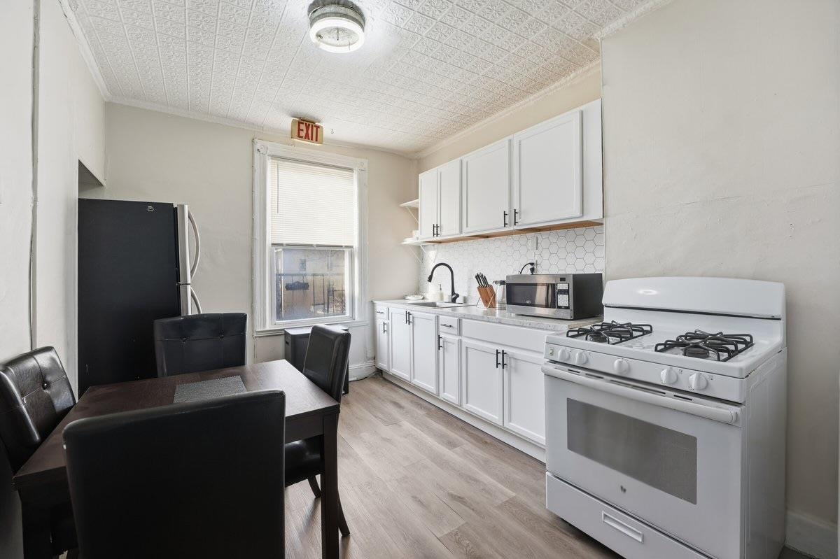 335 47th Street, Unit 3 Union City, NJ 07087 - Photo 4 of 14 a kitchen with a stove a sink and a refrigerator