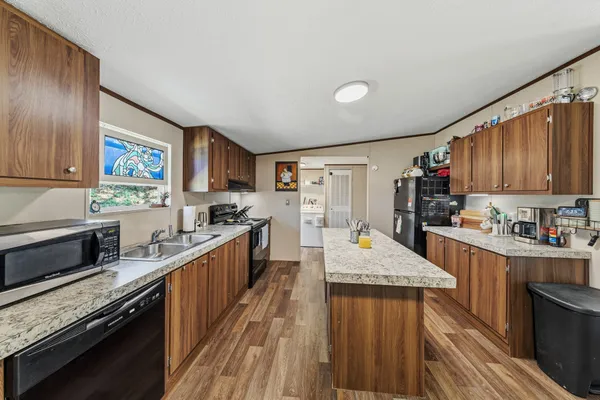 a large kitchen with stainless steel appliances granite countertop plenty wooden cabinets counter space a sink and a stove