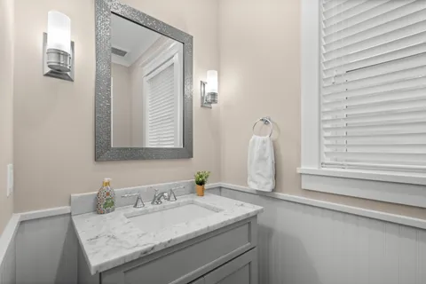 a bathroom with a granite countertop sink and a mirror