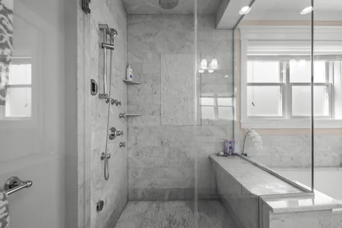 a bathroom with a tub shower and window