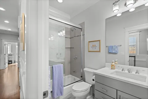 a bathroom with a toilet a sink a mirror a vanity and shower