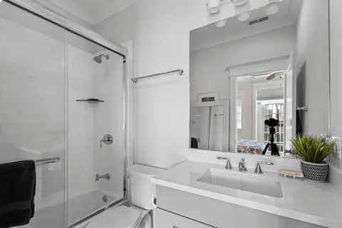a bathroom with a tub a sink and a large mirror