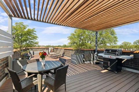 a view of a couches and table in patio with wooden floor