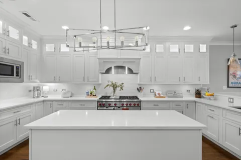 a kitchen with kitchen island a sink stainless steel appliances and cabinets