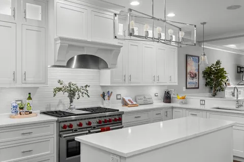 a kitchen with a stove and white cabinets
