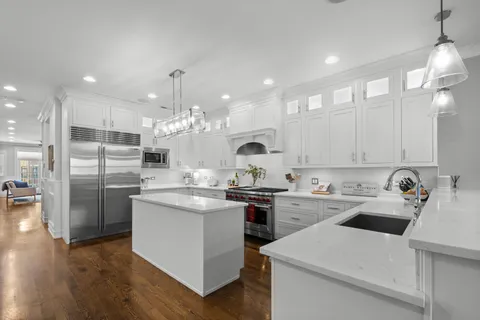 a kitchen with a sink a stove a refrigerator and cabinets