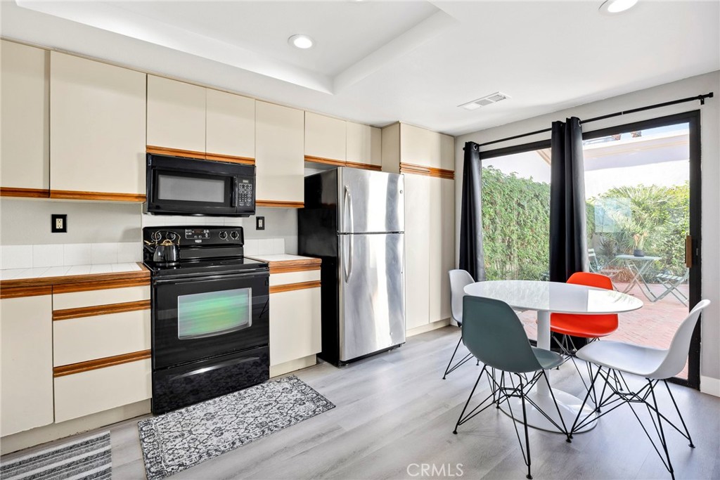 54880 Inverness Way La Quinta, CA 92253 - Photo 13 of 35 a kitchen with stainless steel appliances granite countertop a refrigerator a stove a sink and a dining table with garden view