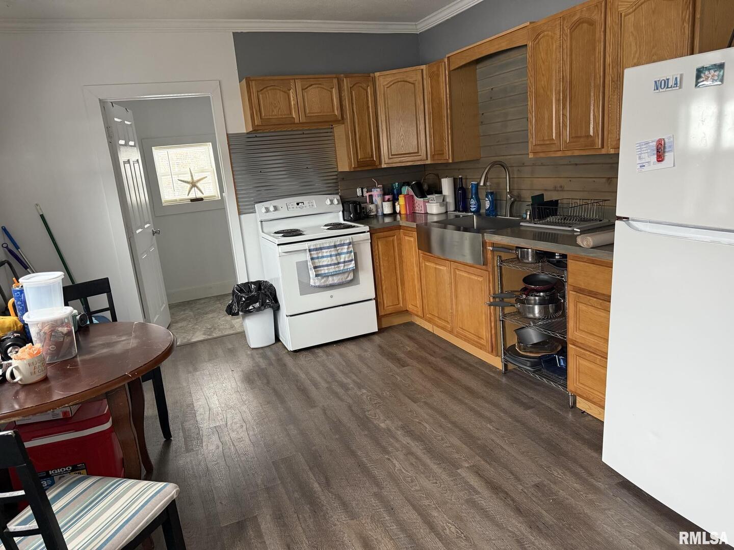 809 South Commercial Street Benton, IL 62812 - Photo 8 of 20 a kitchen with a refrigerator stove and white cabinets with wooden floor