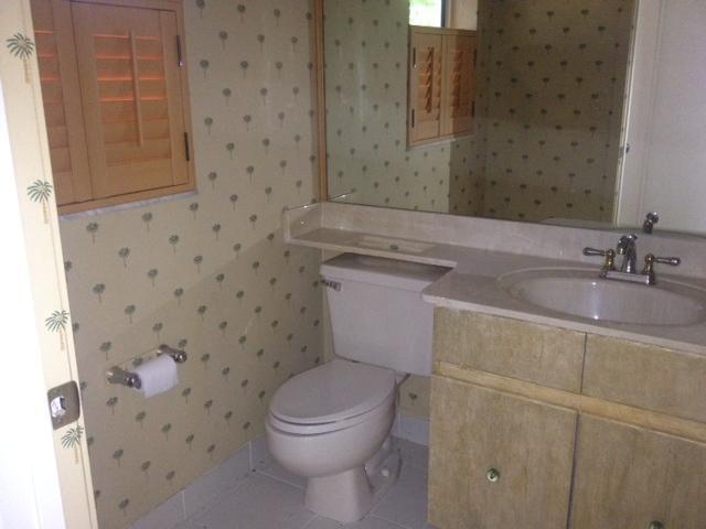 2186 Northwest 52nd Street Boca Raton, FL 33496 - Photo 16 of 23 a bathroom with a granite countertop toilet a sink a mirror and a shower