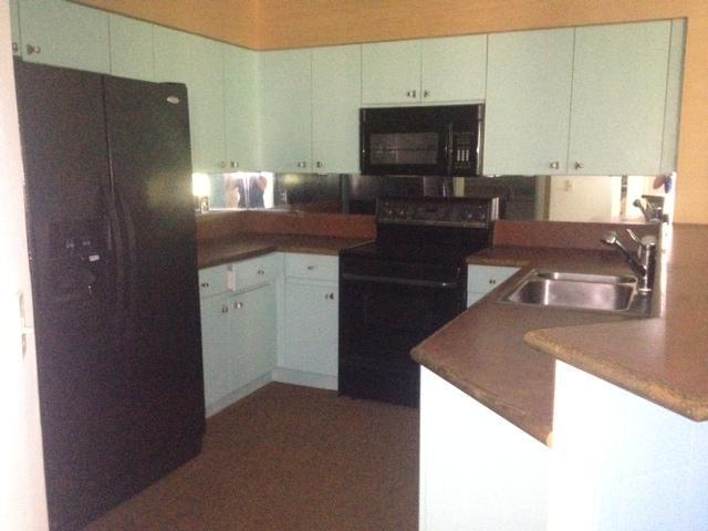 2186 Northwest 52nd Street Boca Raton, FL 33496 - Photo 7 of 23 a kitchen with a refrigerator and a stove top oven