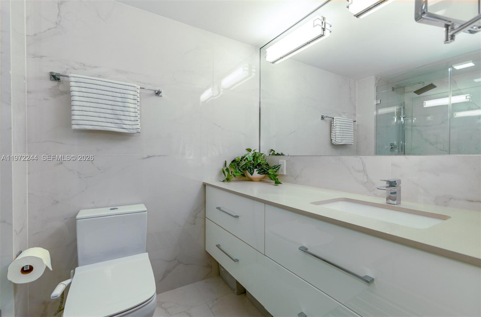 90 Alton Road, Unit 1702 Miami Beach, FL 33139 - Photo 11 of 49 a bathroom with a toilet sink and mirror